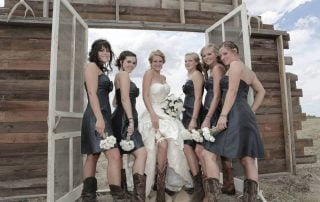 the bride and her brides maids lifting up there dress reviling there legs and cowboy boots