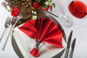 Festive Christmas or wedding table with red napkins on a white tablecloth 