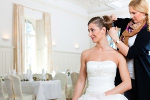 A picture of a wedding planner fixing a bride's hair